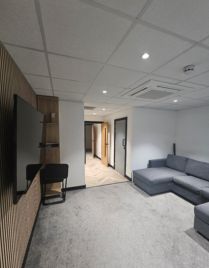 Completed office break-out area with recessed lighting and smoke detection